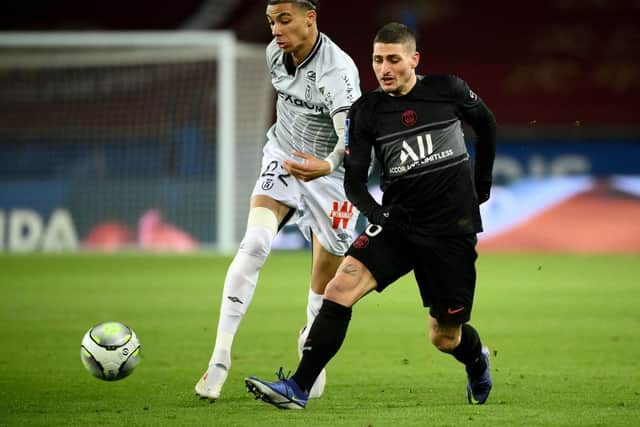 Paris Saint-Germain’s Italian midfielder Marco Verratti (R) fights for the ball with Reims’ French forward Hugo Ekitike (L) during the French L1 football match between Paris Saint-Germain (PSG) and Reims at the Parc des Princes stadium in Paris on January 23, 2022. 