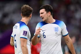 John Stones (L) and Harry Maguire of England speak during the FIFA World Cup Qatar 2022 Group B match between Wales and England  (Photo by Justin Setterfield/Getty Images)