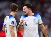 John Stones (L) and Harry Maguire of England speak during the FIFA World Cup Qatar 2022 Group B match between Wales and England  (Photo by Justin Setterfield/Getty Images)