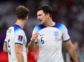 John Stones (L) and Harry Maguire of England speak during the FIFA World Cup Qatar 2022 Group B match between Wales and England  (Photo by Justin Setterfield/Getty Images)