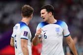 John Stones (L) and Harry Maguire of England speak during the FIFA World Cup Qatar 2022 Group B match between Wales and England  (Photo by Justin Setterfield/Getty Images)