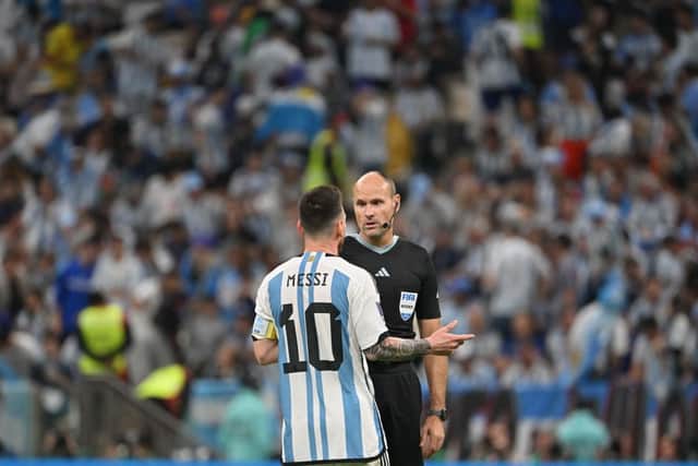 Lionel Messi talks to Spanish referee Antonio Mateu Lahoz during the Qatar 2022 World Cup quarter-final football match between Netherlands and Argentina at Lusail Stadium