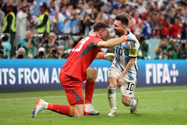 Emiliano Martinez and Lionel Messi of Argentina celebrate after the team's victory in the penalty shoot out during the FIFA World Cup Qatar