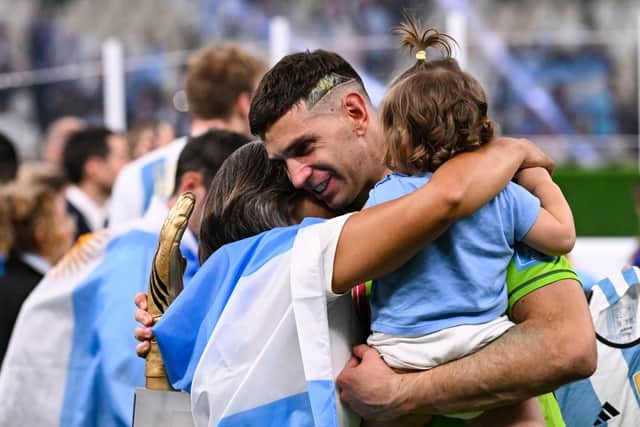 Emiliano Martinez holds the FIFA Golden Glove award as he celebrates with his wife Amanda Mandinha and daughter Ava after Argentina won the Qatar 2022 World Cup final football match between Argentina and France at Lusail Stadium in Lusail, north of Doha on December 18, 2022. (Photo by KIRILL KUDRYAVTSEV/AFP via Getty Images)