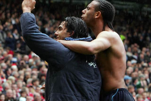Carlos Tevez and Anton Ferdinand celebrate in the Old Trafford rain.