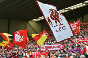 Liverpool fans hold up flags and scarfs in the stands ahead of a match