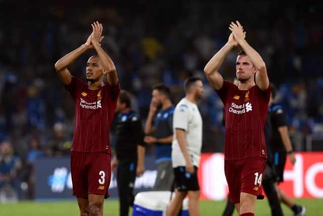 Fabinho and Jordan Henderson of Liverpool applaud the fans after a match