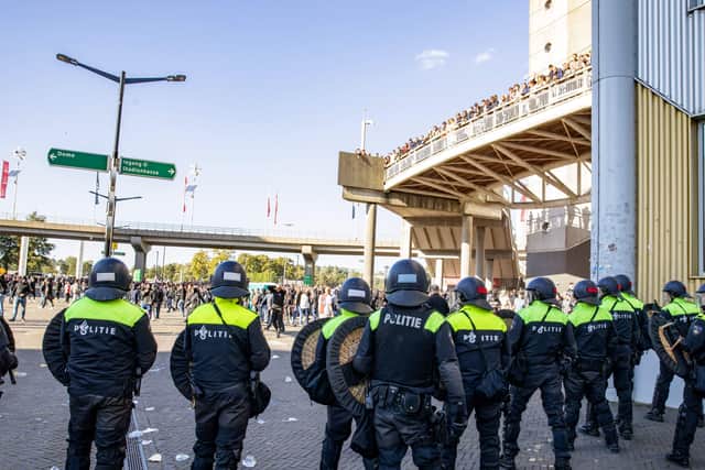 Dutch riot police confront Ajax fans outside the Johan Crujff Arena.