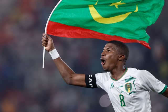 Mauritania's Bodda Mouhsine celebrates victory over Algeria with the national flag