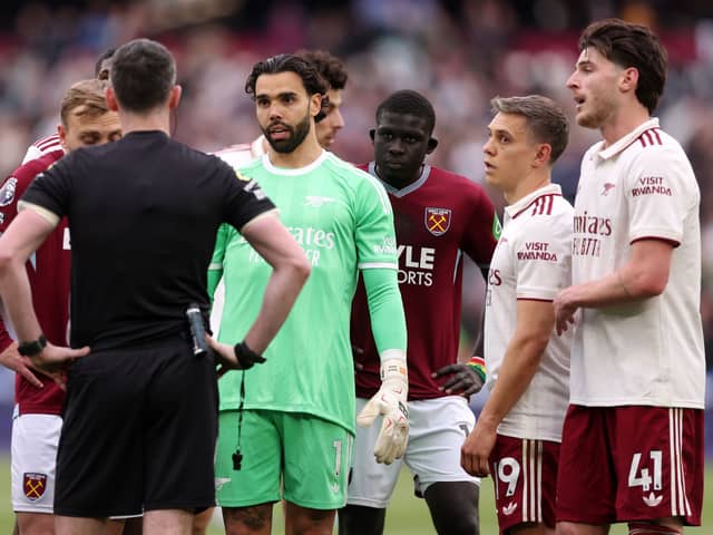 David Raya debates with referee Chris Kavanagh as they wait for VAR's decision.