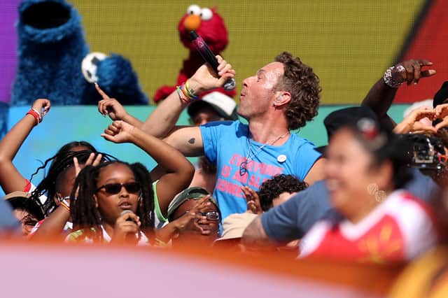 Chris Martin performs alongside two other muppets during the half-time ceremony