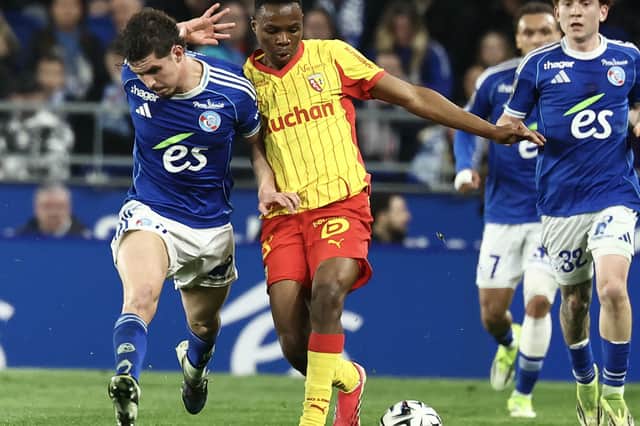 Sangaré fends off a Strasbourg player while playing for Lens