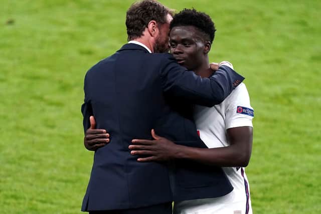 England's Bukayo Saka (right) is congratulated by manager Gareth Southgate.