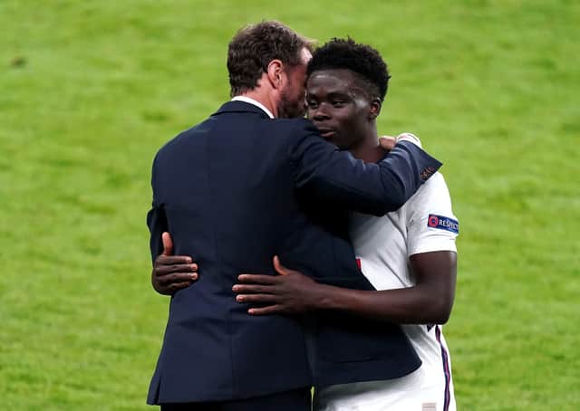 England's Bukayo Saka (right) is congratulated by manager Gareth Southgate.
