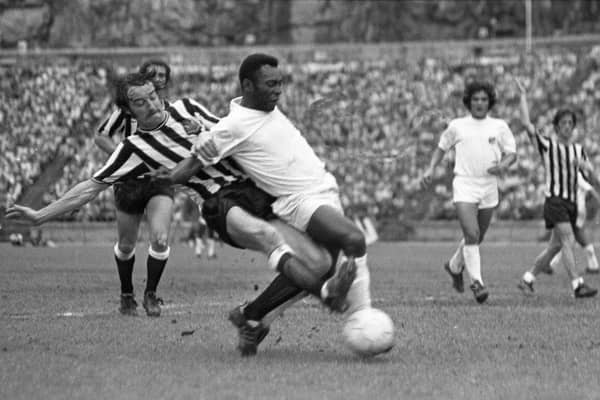 Newcastle United defender Frank Clark tackles Pele during the challenge match in Hong Kong. Pic courtesy of Paul Joannou/NUFC archive.