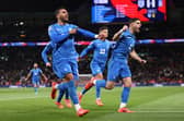 Vangelis Pavlidis Greece celebrates scoring his team's first goal as he gestures towards his black armband in honour of the passing of former Greek player George Baldock