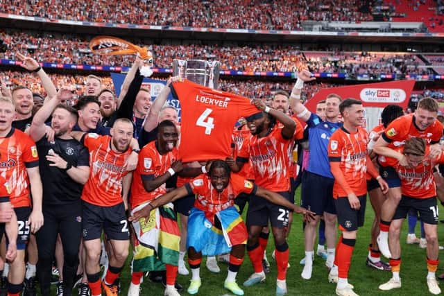 The Hatters players face the camera with Tom Lockyer's shirt after winning promotion