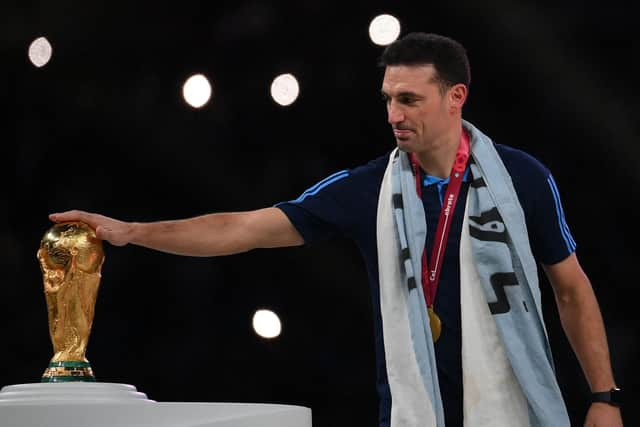 Argentina's coach Lionel Scaloni touches the World Cup trophy as the team receives their gold medals during the Qatar 2022 World Cup trophy ceremony after the football final match between Argentina and France at Lusail Stadium in Lusail, north of Doha on December 18, 2022. - Argentina won in the penalty shoot-out. (Photo by FRANCK FIFE / AFP) (Photo by FRANCK FIFE/AFP via Getty Images)