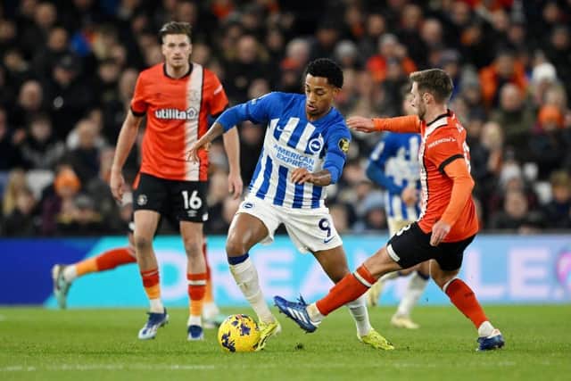 Joao Pedro of Brighton & Hove Albion is challenged by Jordan Clark of Luton Town
