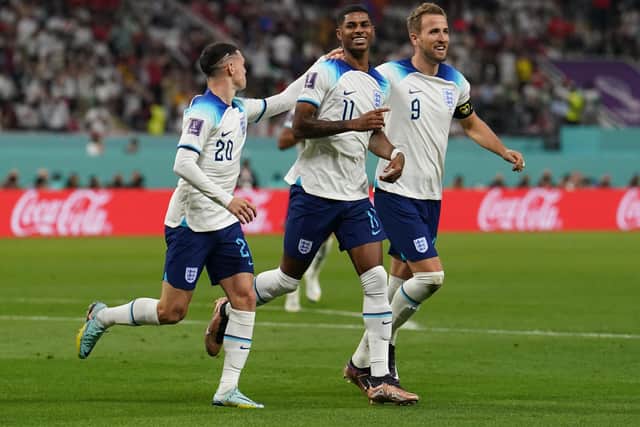 England's Marcus Rashford (centre) celebrates with Phil Foden (left) and Harry Kane after scoring their side's fifth goal of the game during the FIFA World Cup Group B match at the Khalifa International Stadium in Doha, Qatar. Picture: Martin Rickett/PA Wire.